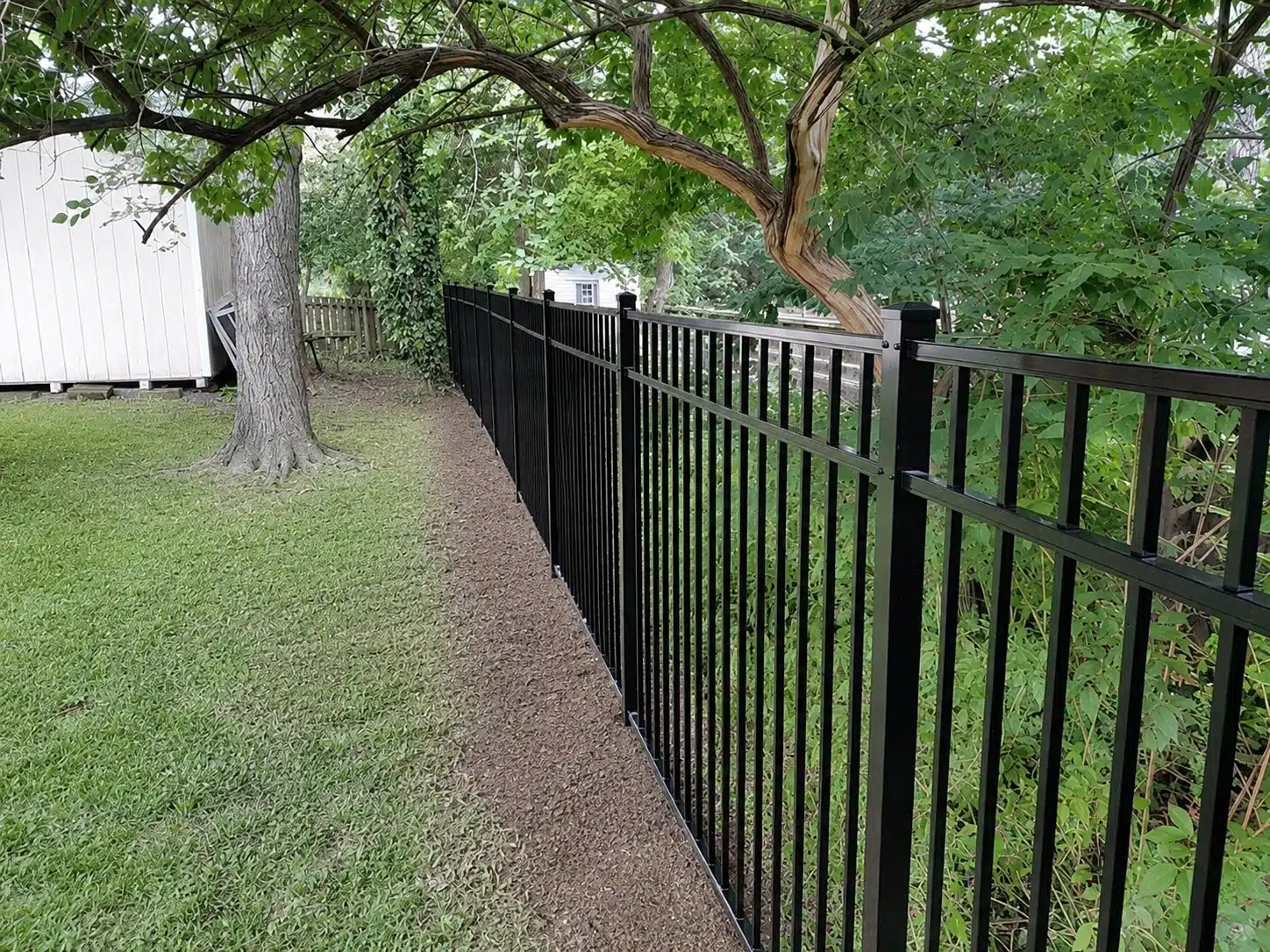 54-inch three-rail black aluminum fence installed along a shaded backyard in Severna Park, MD.