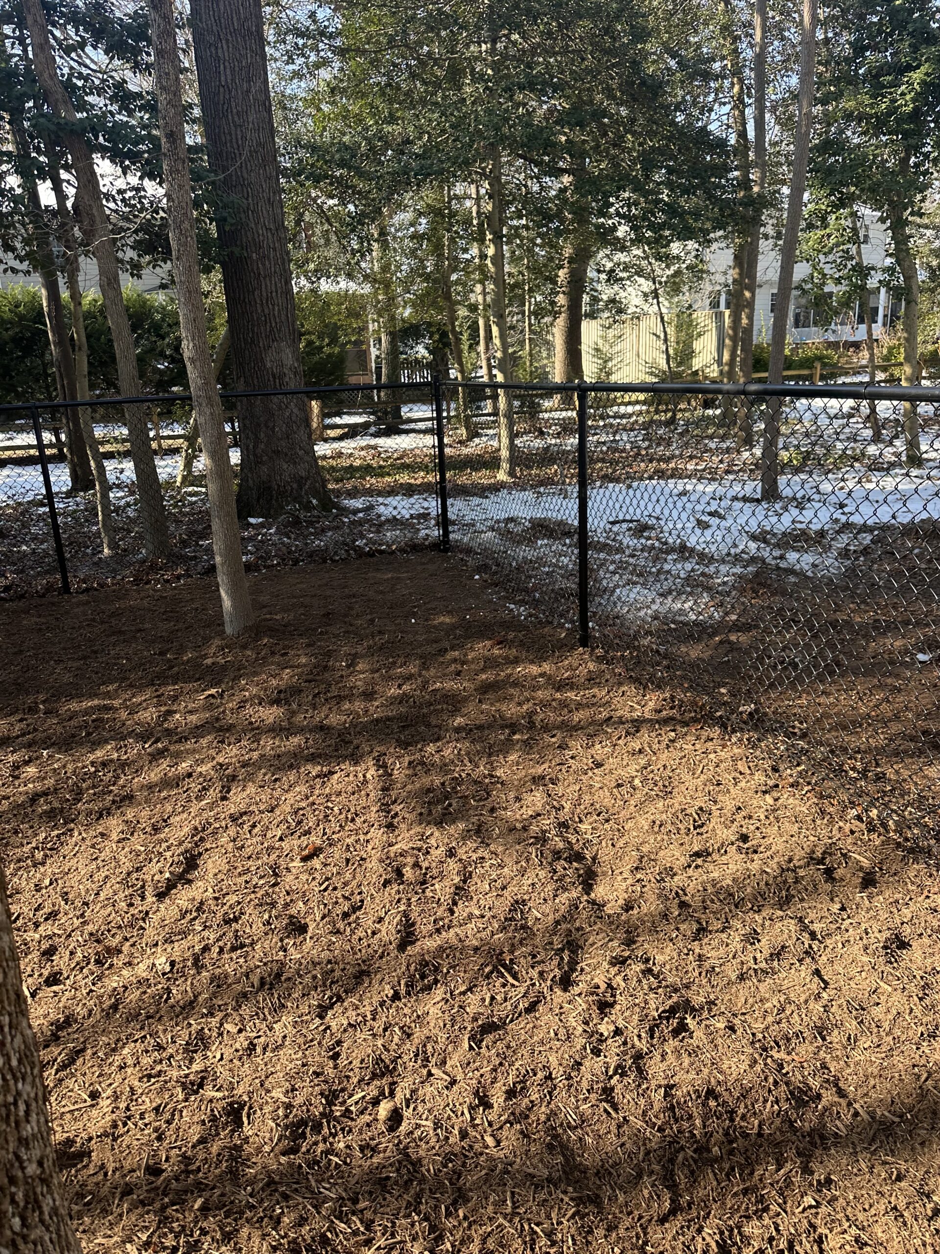 black chain link dog park fencing with wood mulch ground in Pasadena Maryland