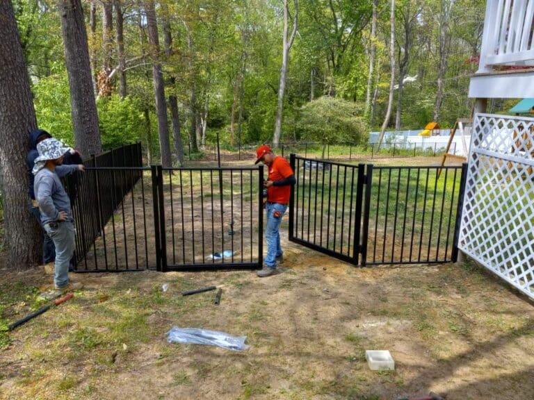 a man installing a 4 foot aluminum or wrought iron gate