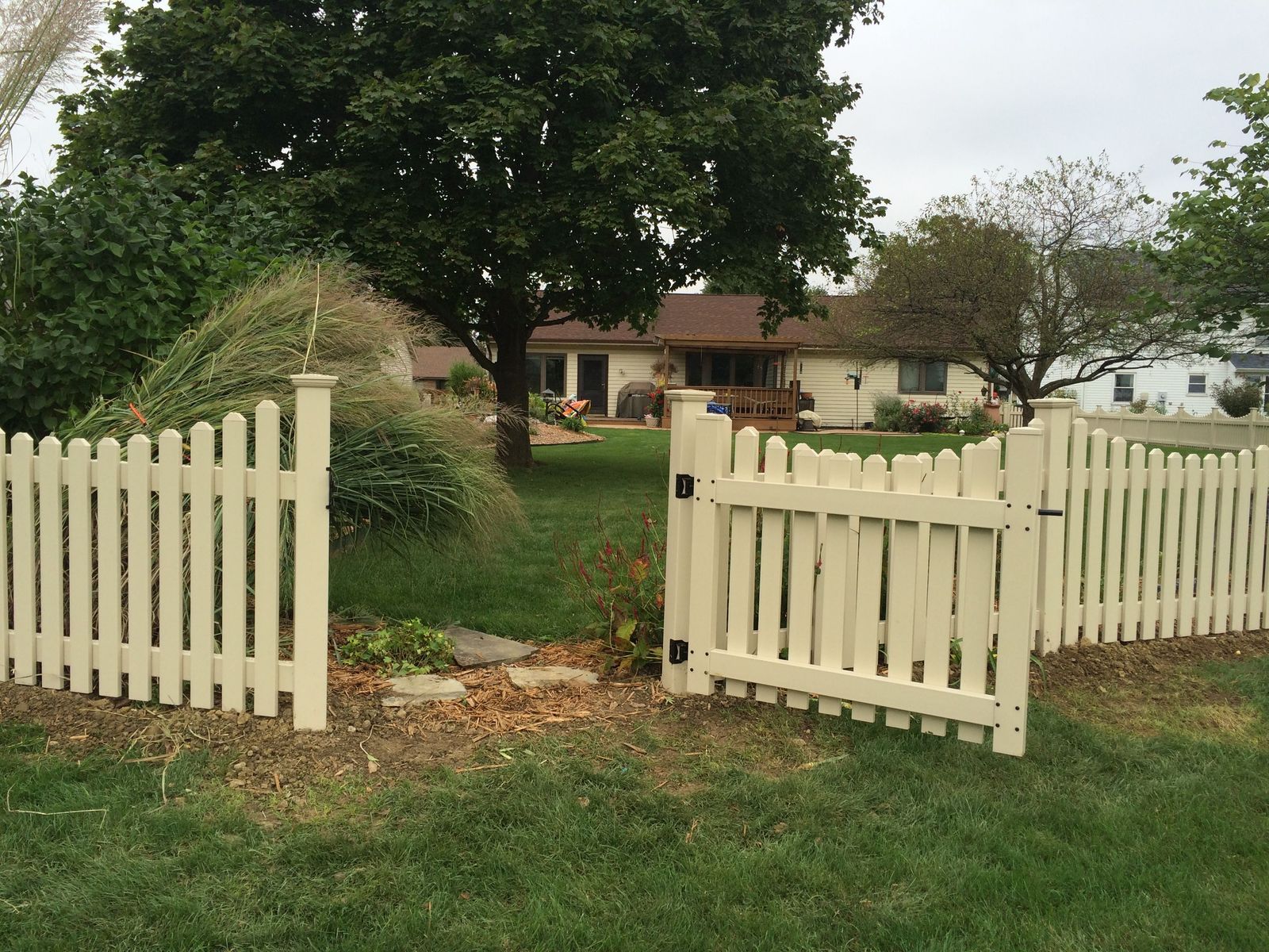 Beautiful tan vinyl fence installation with gate in Fort Wayne, Indiana.