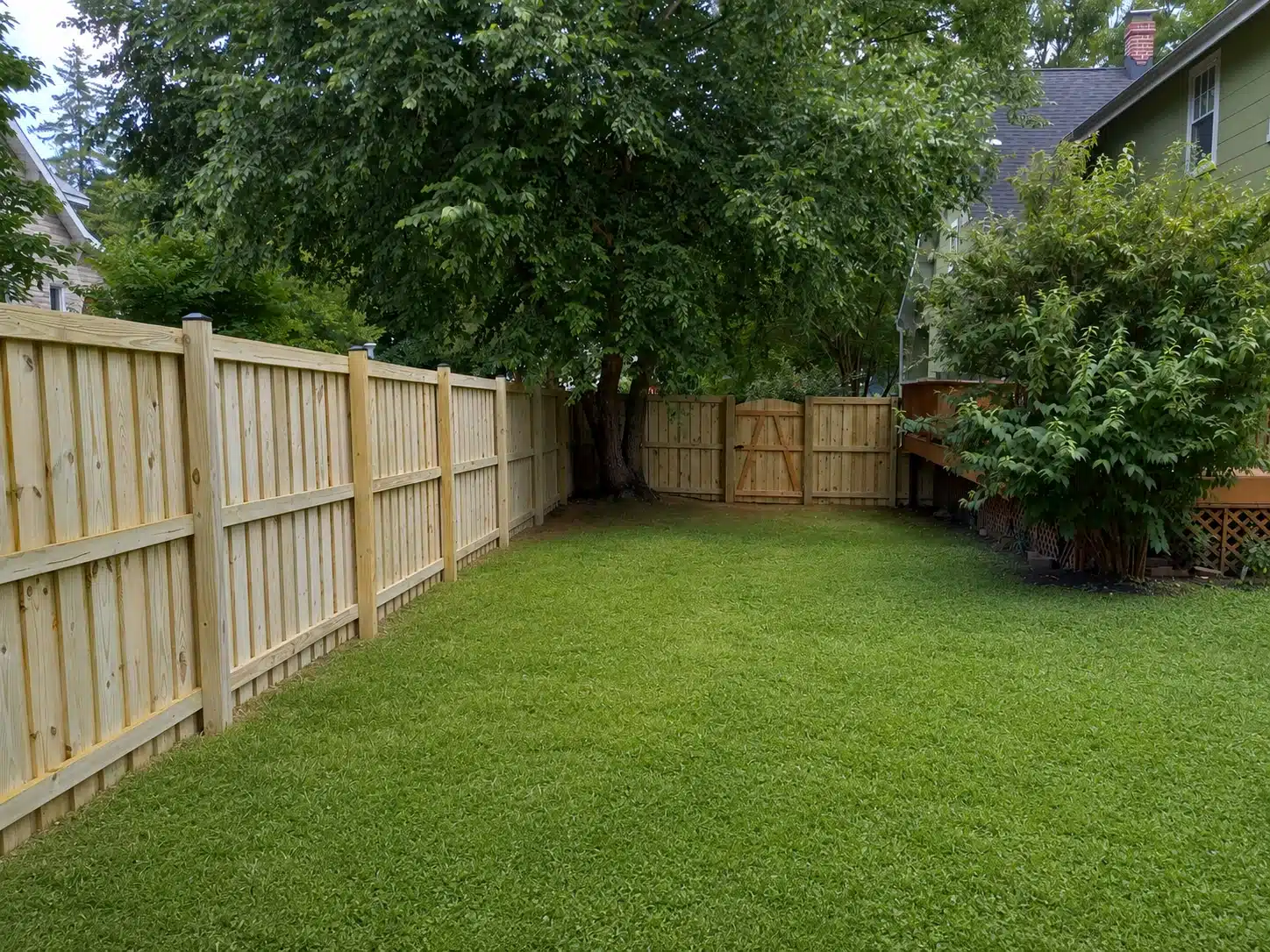 Board-on-board wood privacy fence surrounding a large residential backyard in Pasadena, MD.