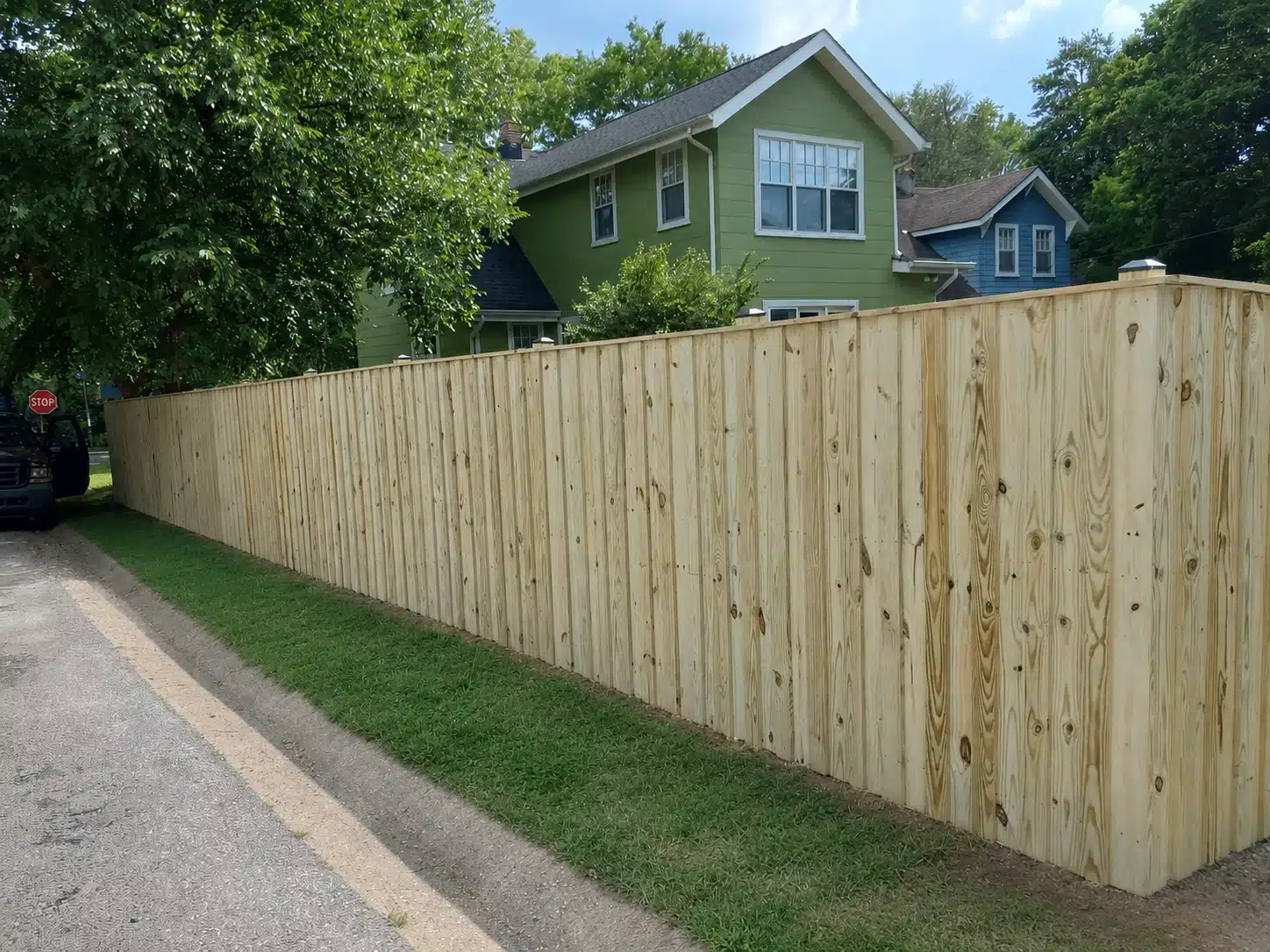 Board-on-board wood privacy fence installed along a residential street in Pasadena, MD.