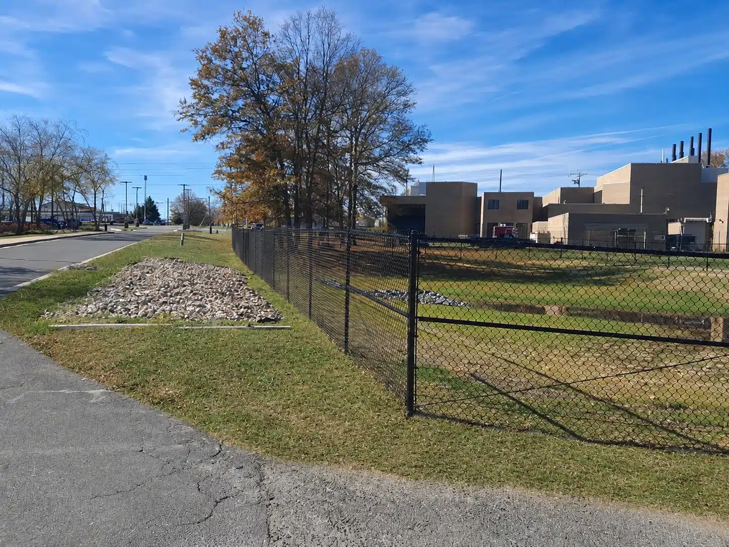 Black chain-link perimeter fence enclosing an open commercial property in Severna Park.