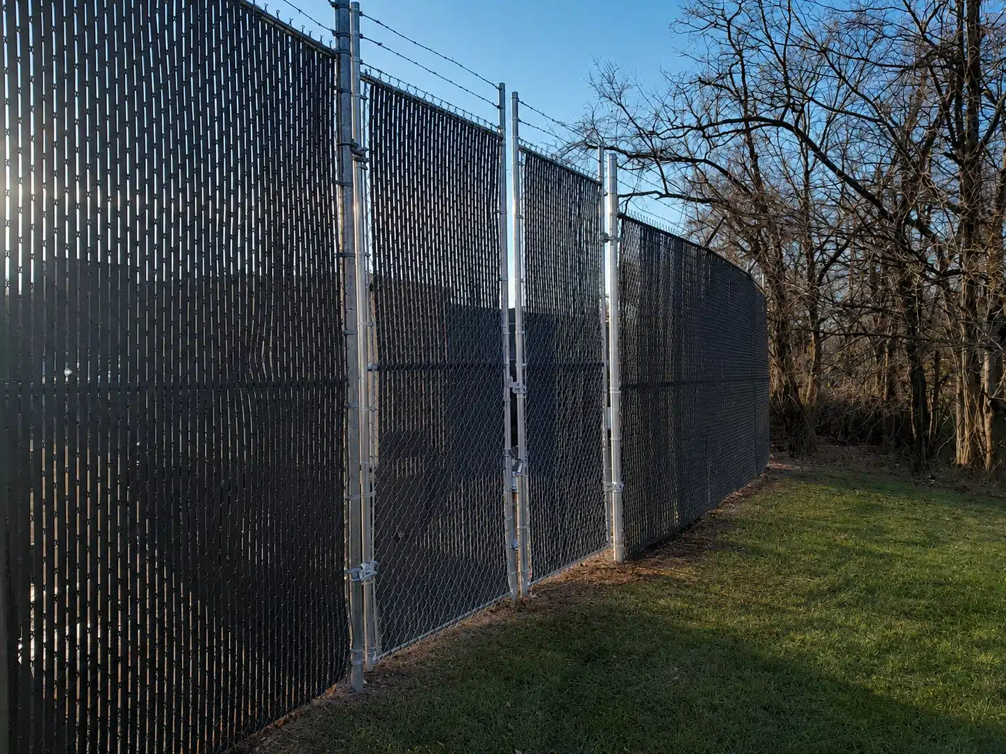 Galvanized chain-link fence with dark privacy slats around a secured area in Severna Park.