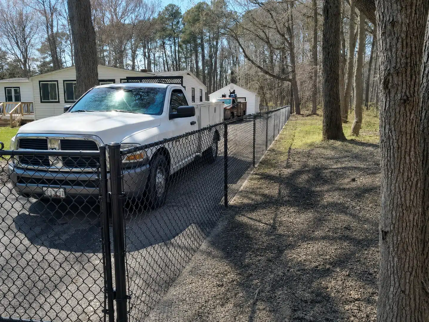 Black chain-link pet and dog containment fence along a residential property boundary in Severna Park.