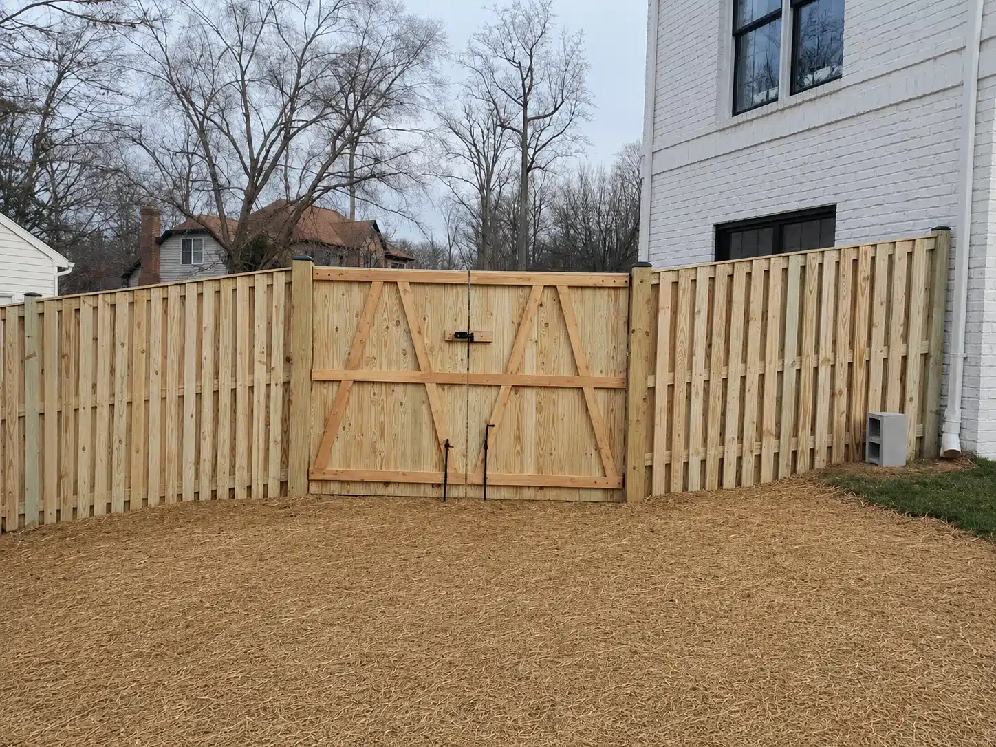 Wood privacy fence with a custom double gate for a home in Severna Park, MD.