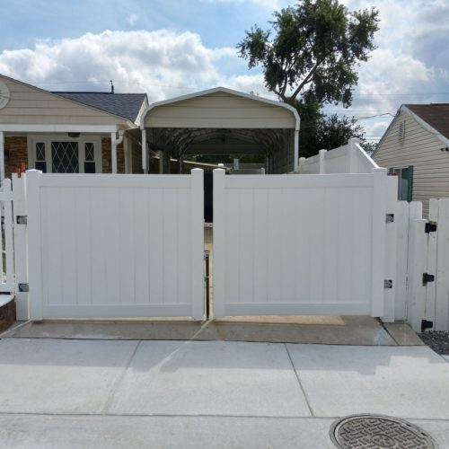 a white privacy vinyl driveway gate
