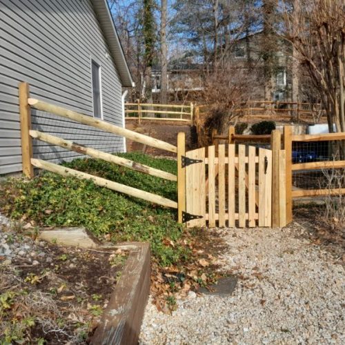 Three-rail split-rail fence with welded wire installed along a terraced backyard in Crownsville, MD