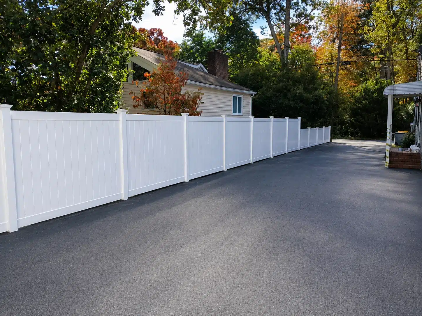 Long white vinyl fence installed along a driveway in Severna Park, MD.