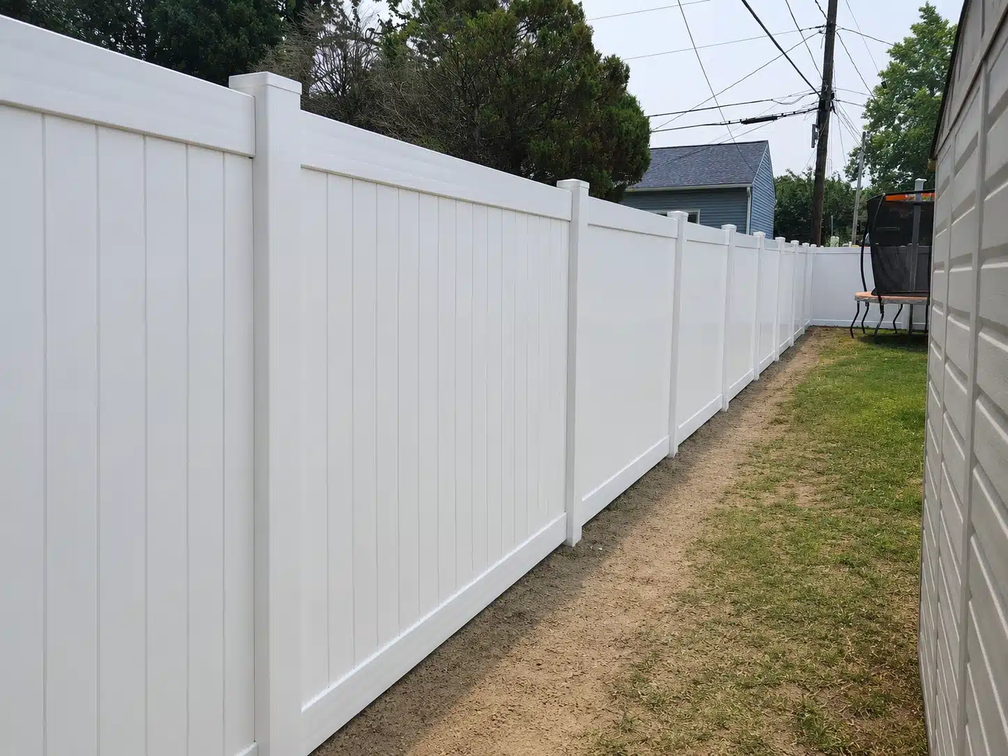 White vinyl privacy fence along a side yard in Severna Park, MD.