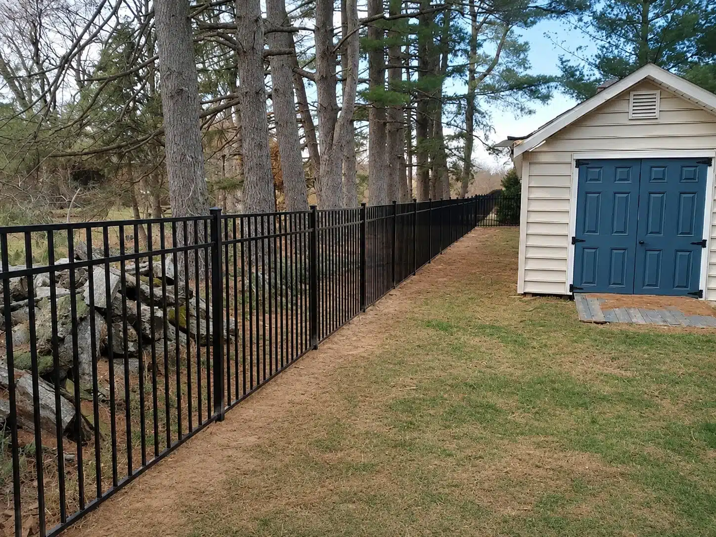 Black flat-top picket aluminum fence installed beside a residential patio in Severna Park, Maryland.