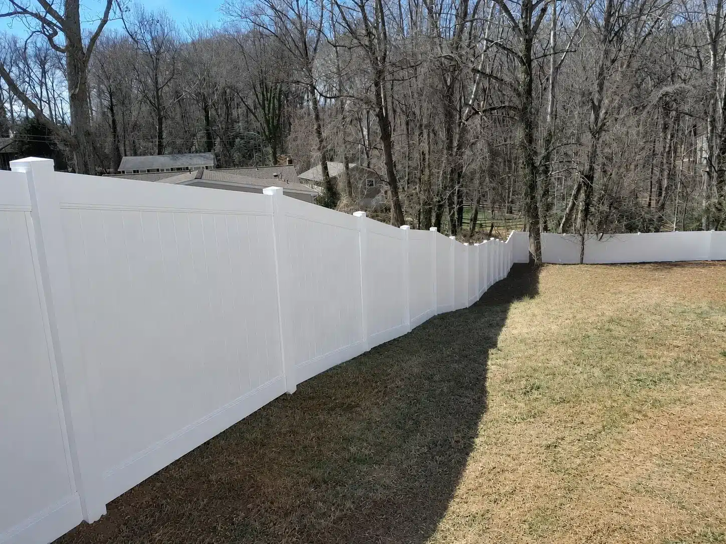 Full privacy vinyl fence installed on a sloped residential yard in Glen Burnie, MD.