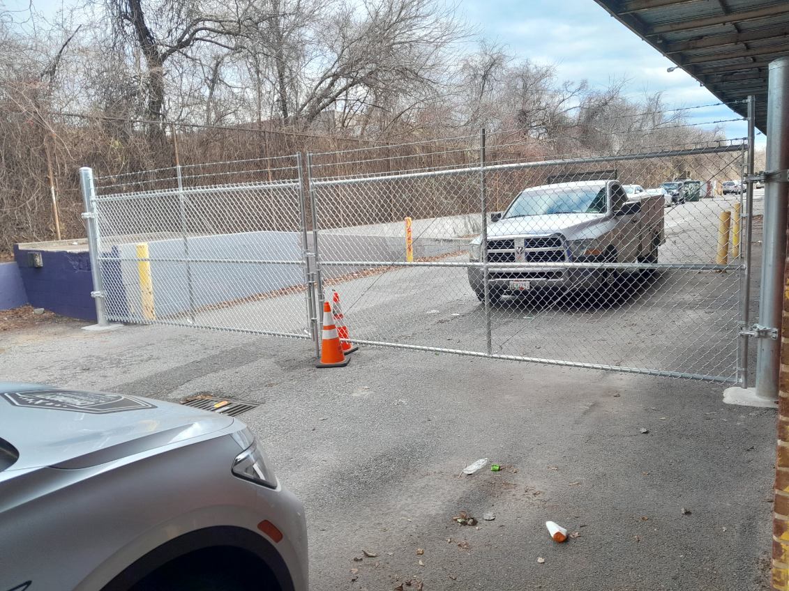 Chain link perimeter security fence controlling vehicle access to a commercial property