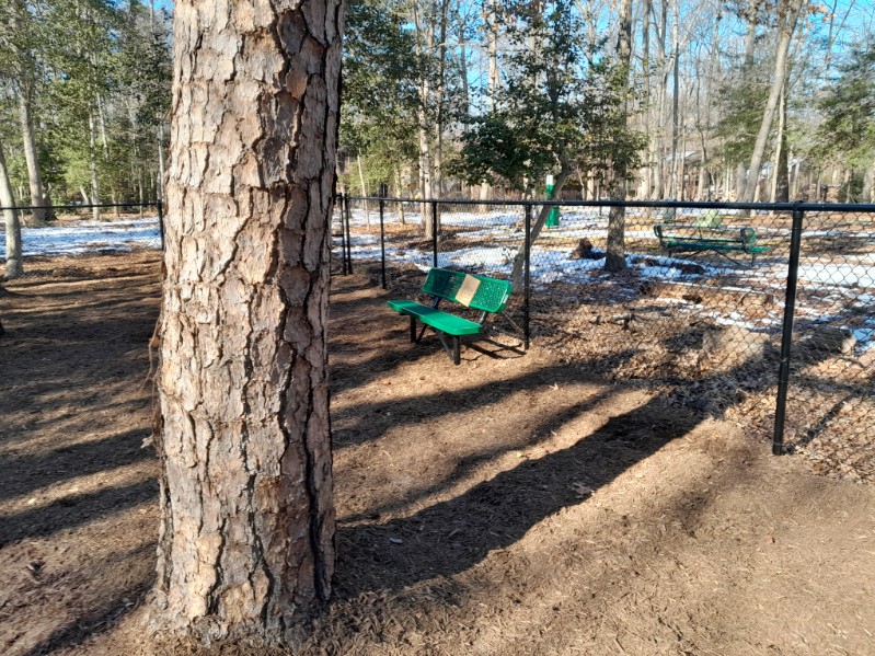 green bench inside fenced dog park area in Pasadena Maryland
