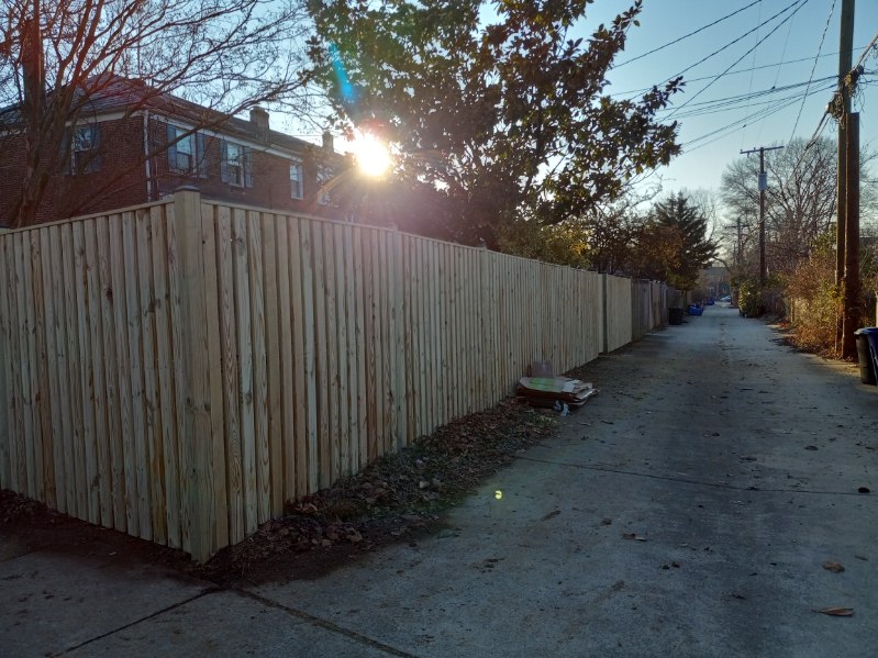 shadowbox-style wood fence installation beside a sidewalk in Pasadena MD