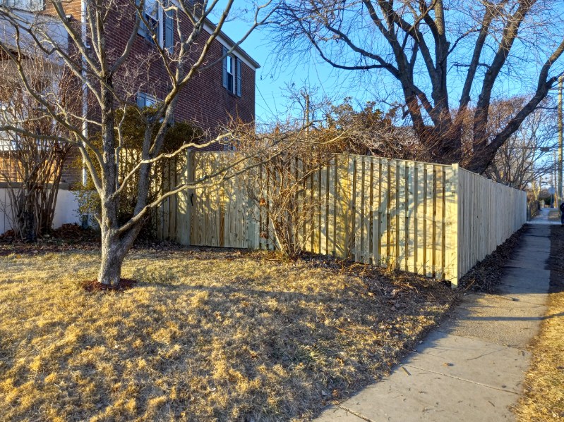 fresh pressure-treated wood fence surrounding a suburban yard in Pasadena Maryland