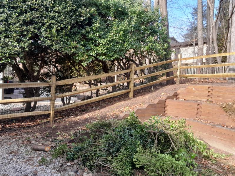 Welded wire attached to a split-rail fence for added security around a wooded yard in Crownsville