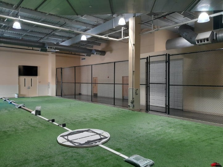 High chain-link fence panels surrounding an indoor turf area for athletic use in Crofton, MD