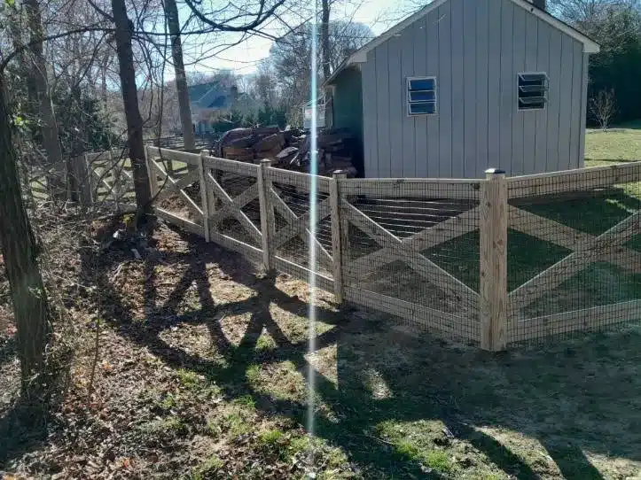 double-gate crossbuck wooden fence installed beside a home in Millersville MD