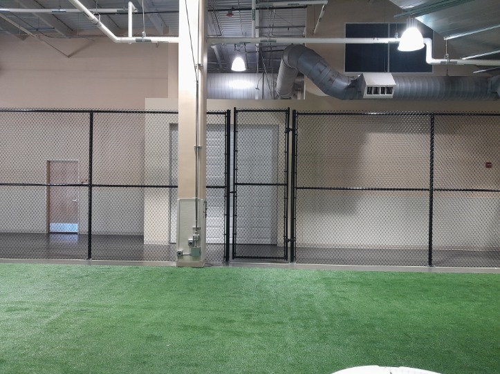 Black chain-link safety fencing dividing an indoor training field in Crofton, Maryland
