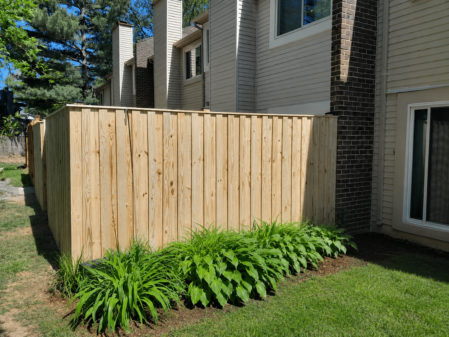 Pressure-treated board-on-board privacy fence enclosing a residential patio area in Pasadena, MD.