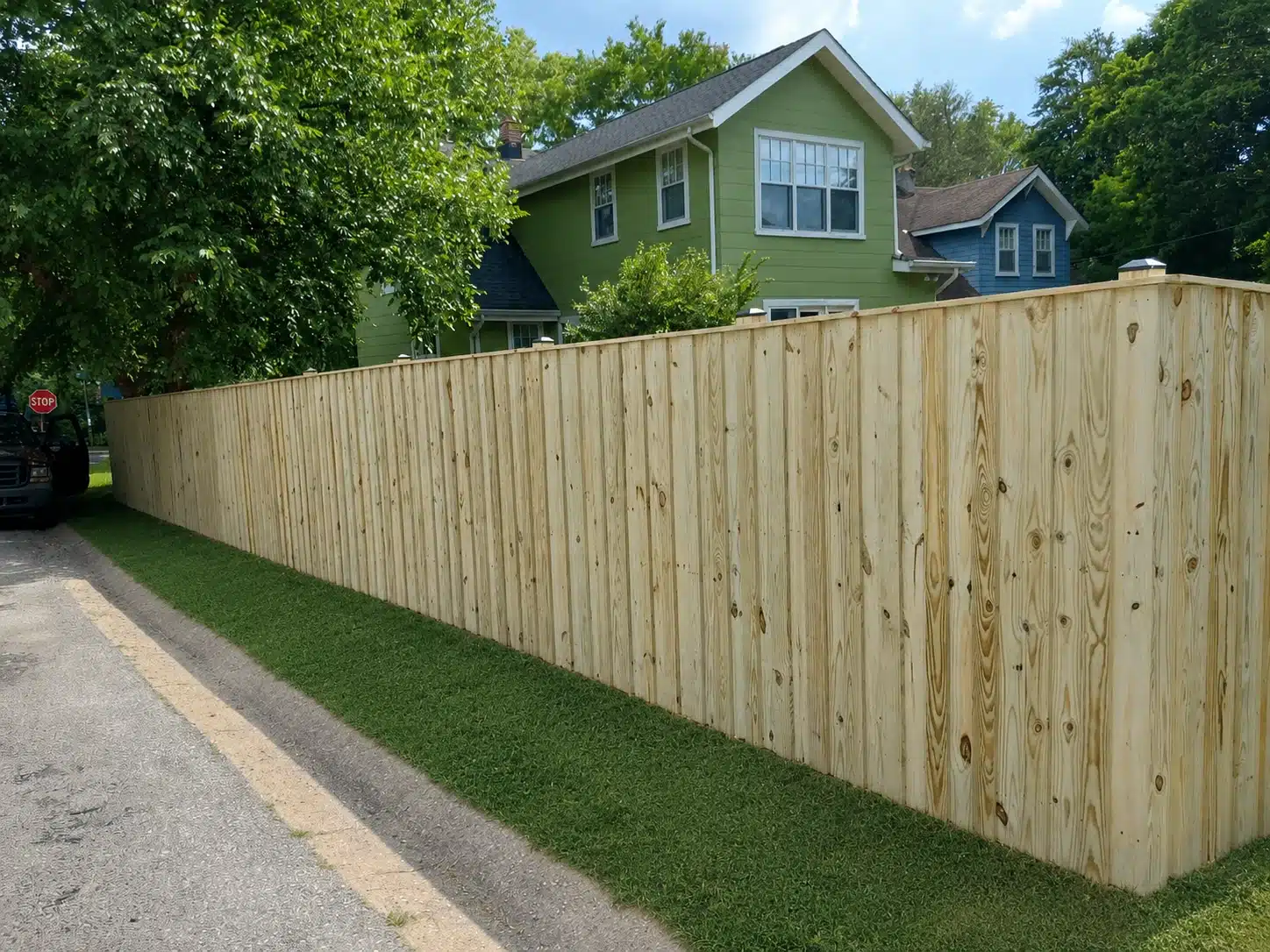 Pressure-treated board-on-board privacy fence installed along a residential street in Pasadena, MD.