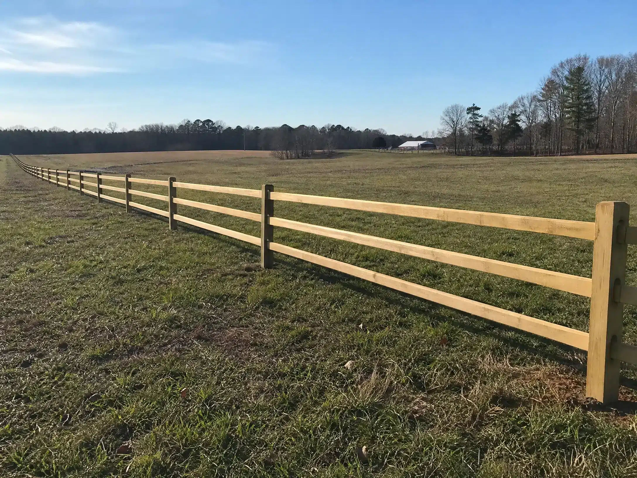 Ranch ranch fence extending across an open field in Anne Arundel County, MD.