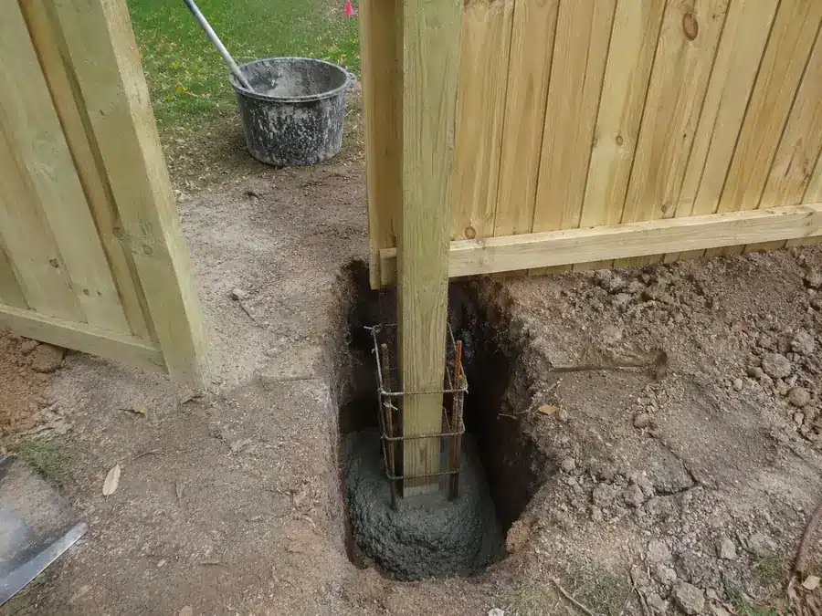 Measured wood fence post hole with gravel base prepared for Glen Burnie soil conditions.