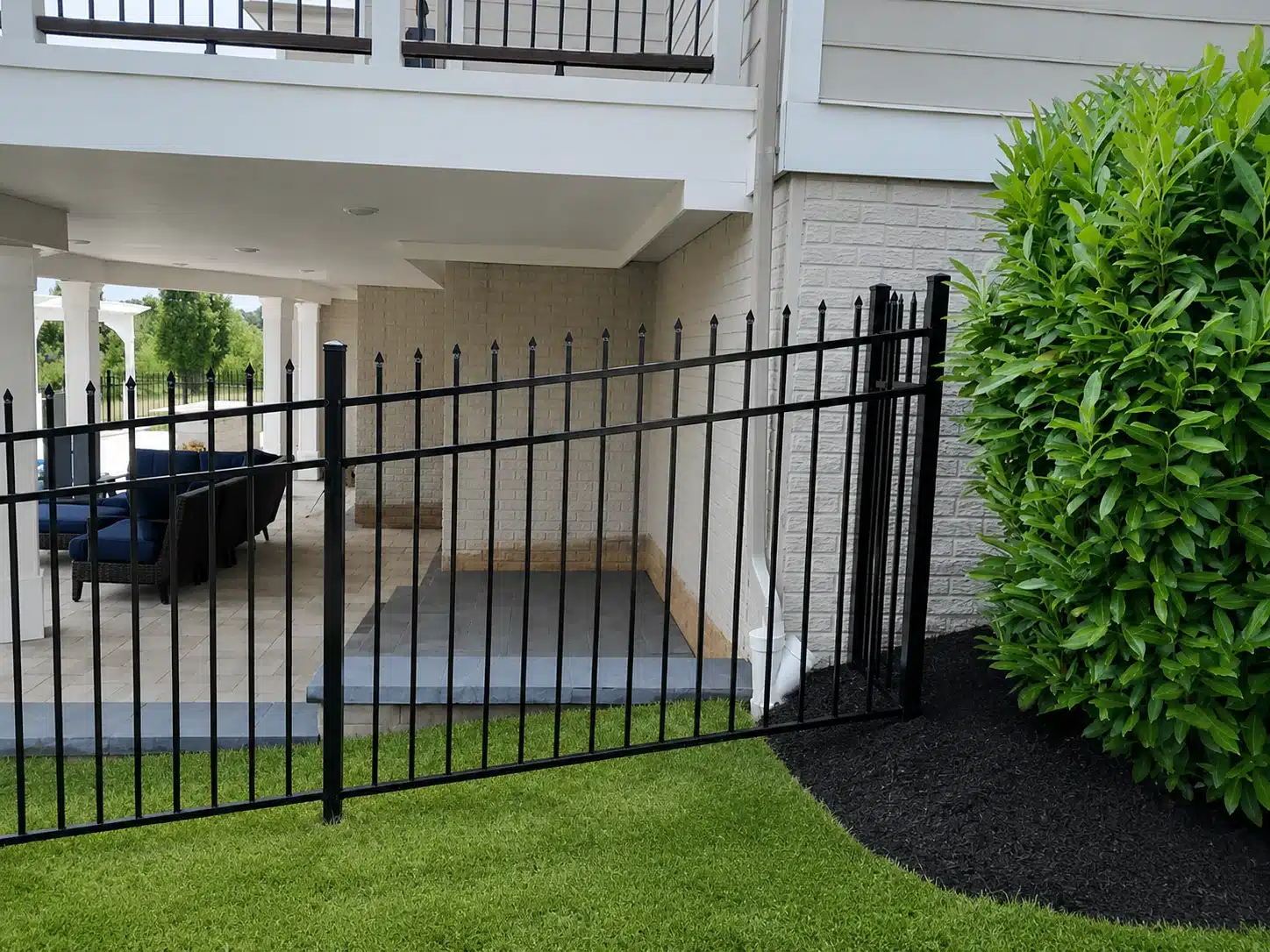 Black spear-top aluminum fence surrounding a covered backyard patio in Severna Park, Maryland.