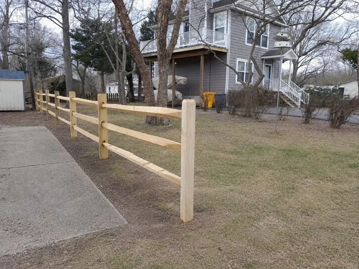 Three-rail split rail fence installed along a residential front yard in Anne Arundel County, MD.