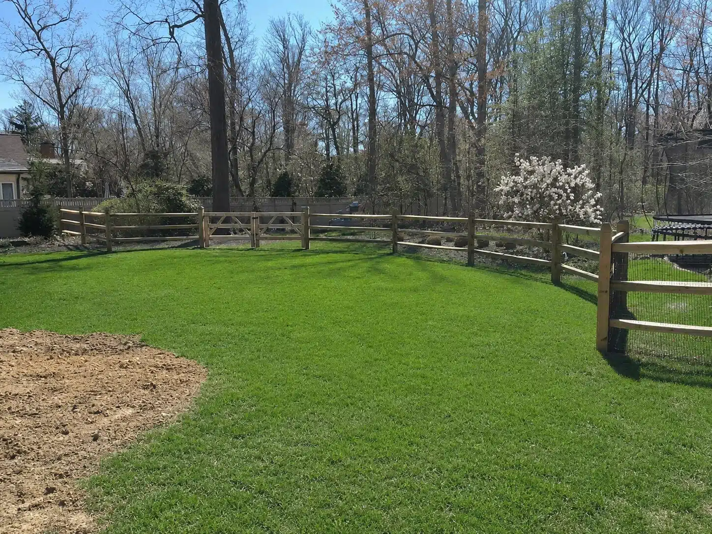 Split rail fence with wire mesh enclosing a large open lawn in Anne Arundel County, MD.