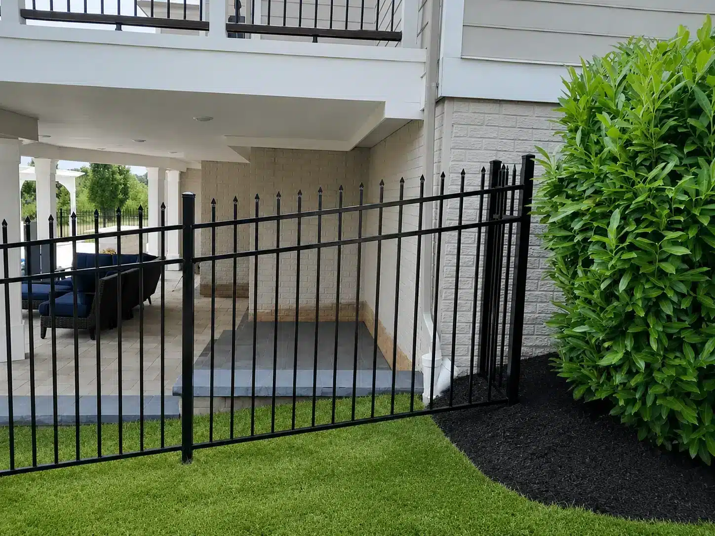 Black ornamental steel fence surrounding a backyard patio area at a Maryland home.