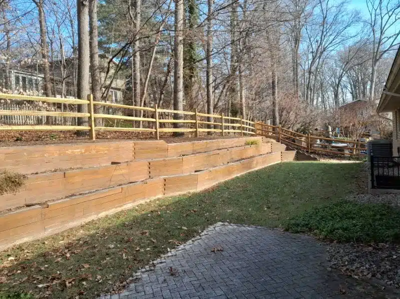Wood three-rail split-rail fence along a landscaped yard in Crownsville, Maryland