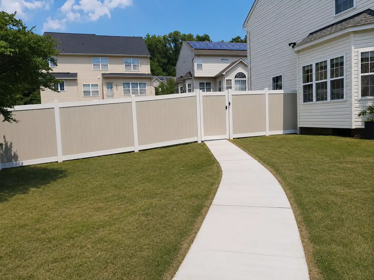 Tan vinyl privacy fence with a matching walk gate beside a backyard path in Glen Burnie, MD.