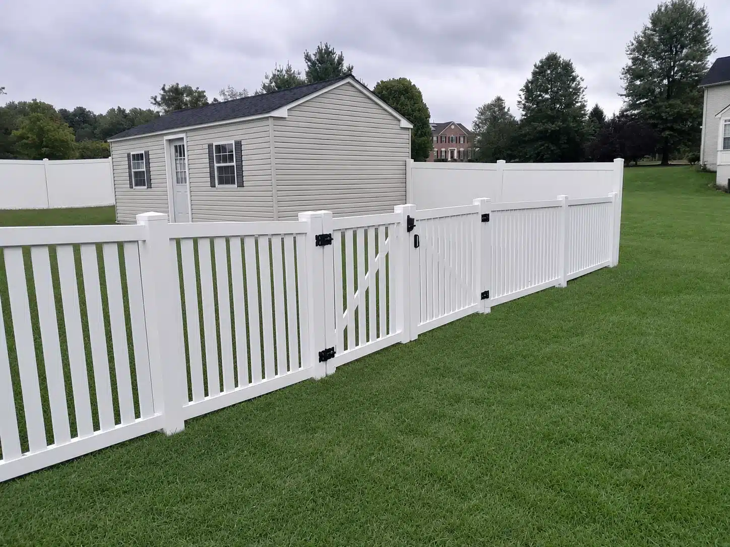 White vinyl picket fence with gate in a residential yard in Glen Burnie, MD.
