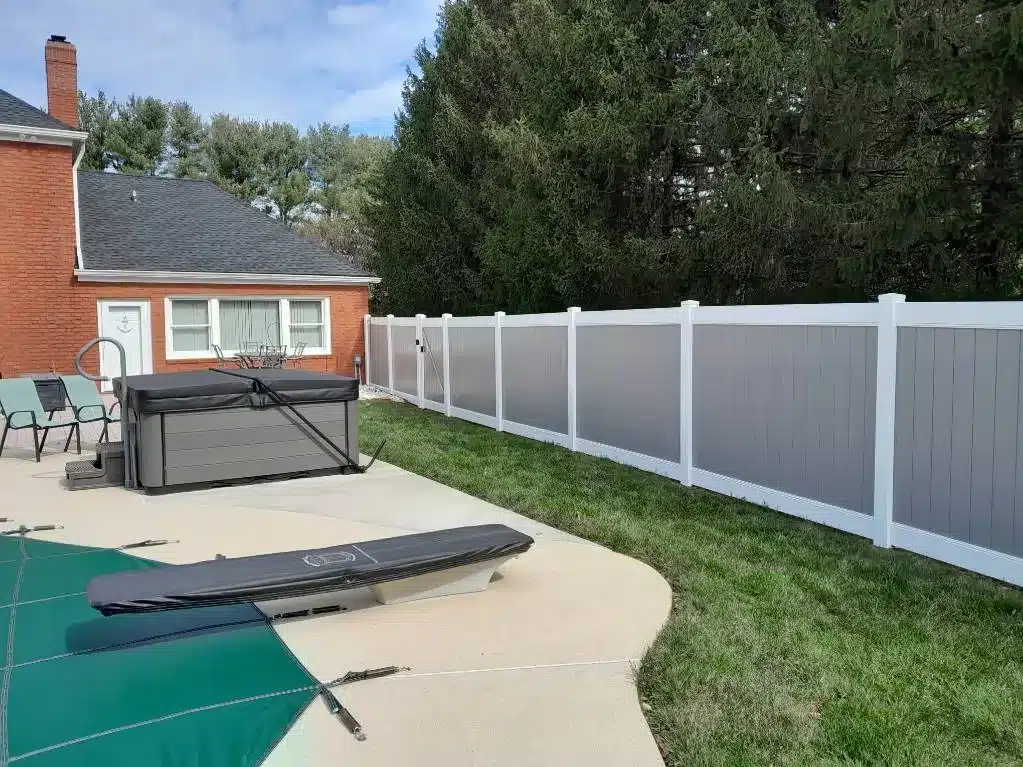 White and gray vinyl privacy fence surrounding a backyard pool and patio in Severna Park, Maryland.