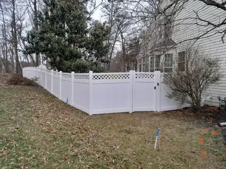 White vinyl privacy fence with lattice-top panels and a gate in a Severna Park, Maryland backyard.