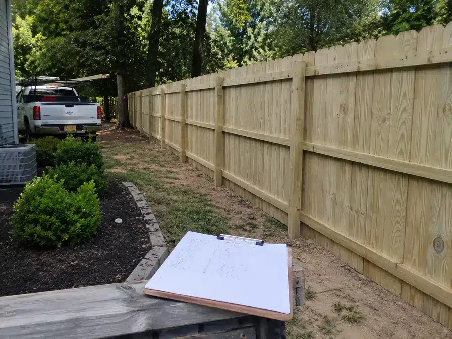 Wood fence job site inspection in Glen Burnie with contractor assessing fence installation progress.