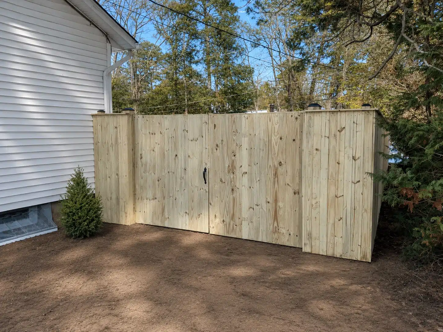 Tall wood privacy fence with a double gate installed beside a home in Glen Burnie, MD.