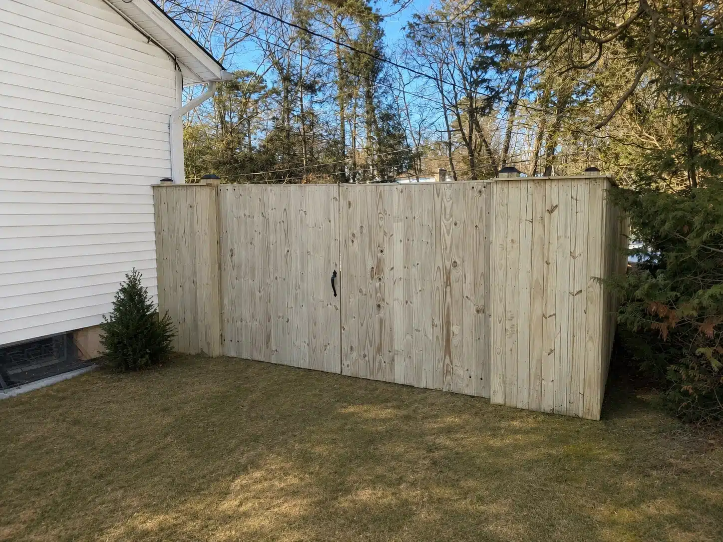Tall wood privacy fence with a double gate installed beside a home in Glen Burnie, MD.