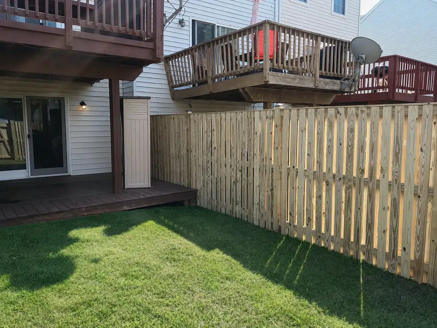New wood privacy fence installed beside a backyard deck in Severna Park, Maryland.